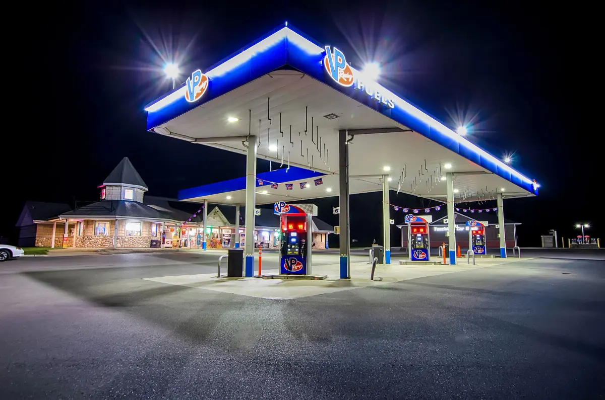 Gas station canopy and pylon signs lit up at night